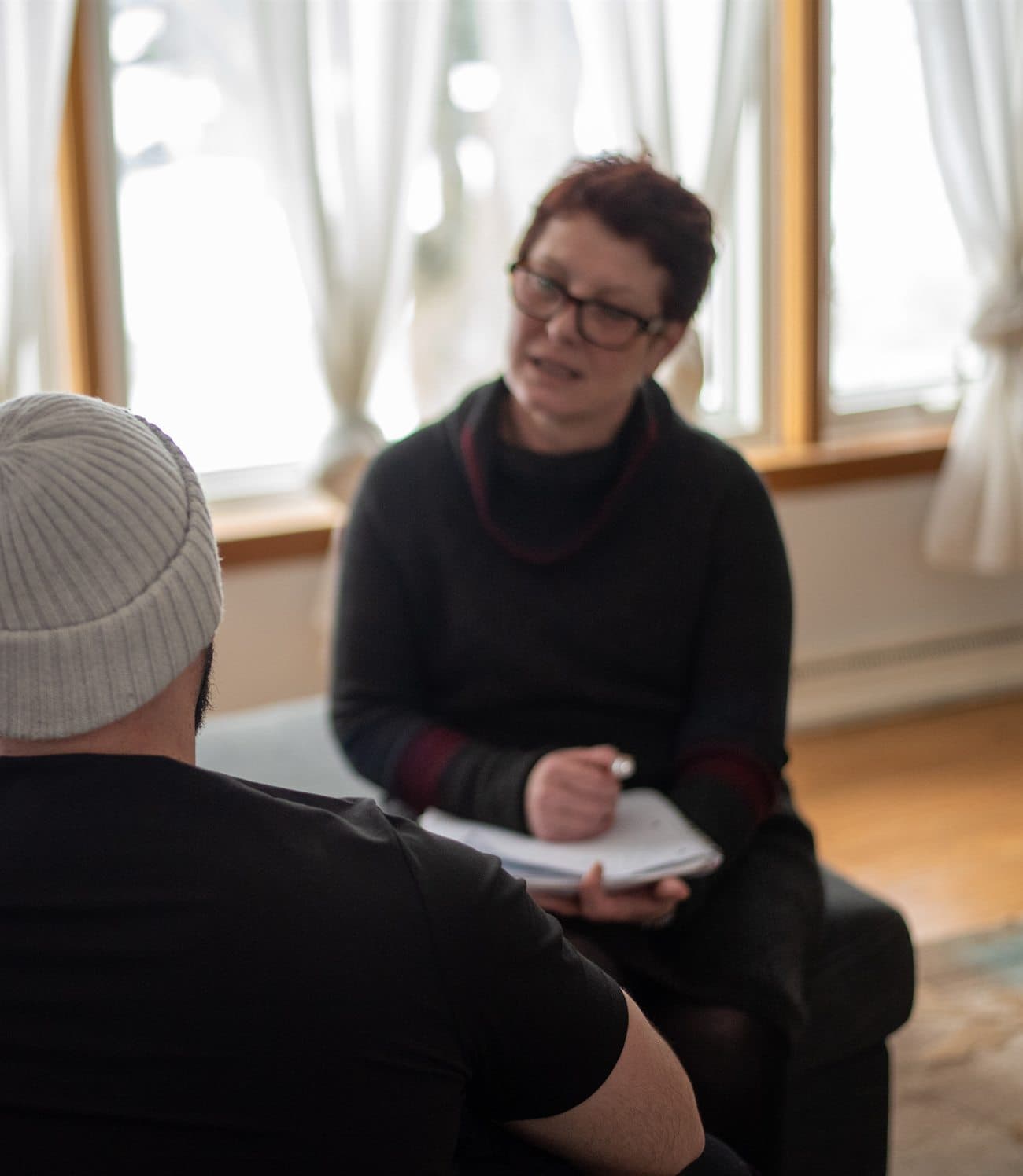 A calm, attentive counselling session in a warm, light-filled room.